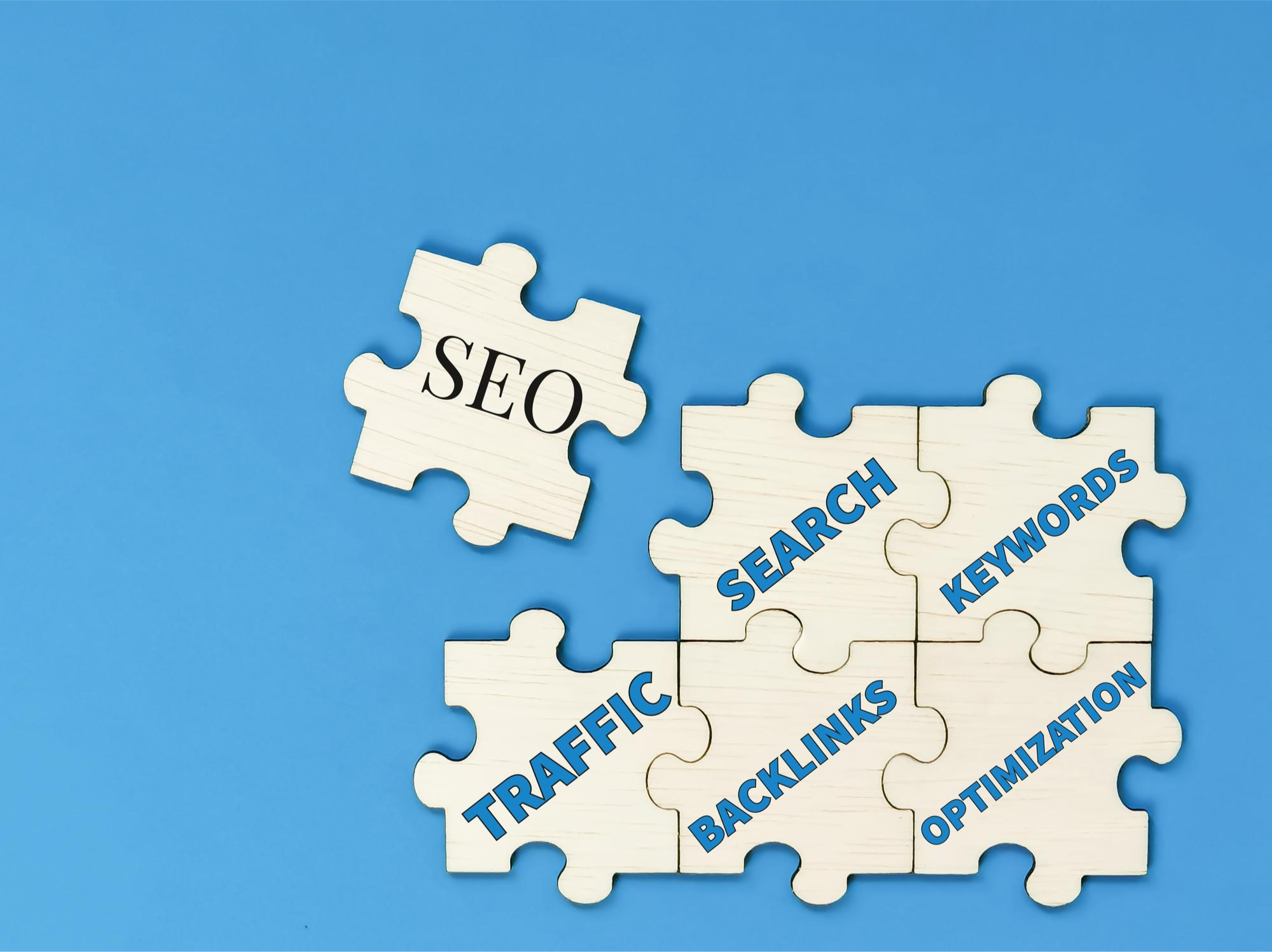 An image of S E O puzzle pieces fitting together: search, keywords, traffic, backlinks, and optimization
